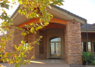 Massive engineered wood curved beam defines a grand entrance to a craftsman style home in Temecula